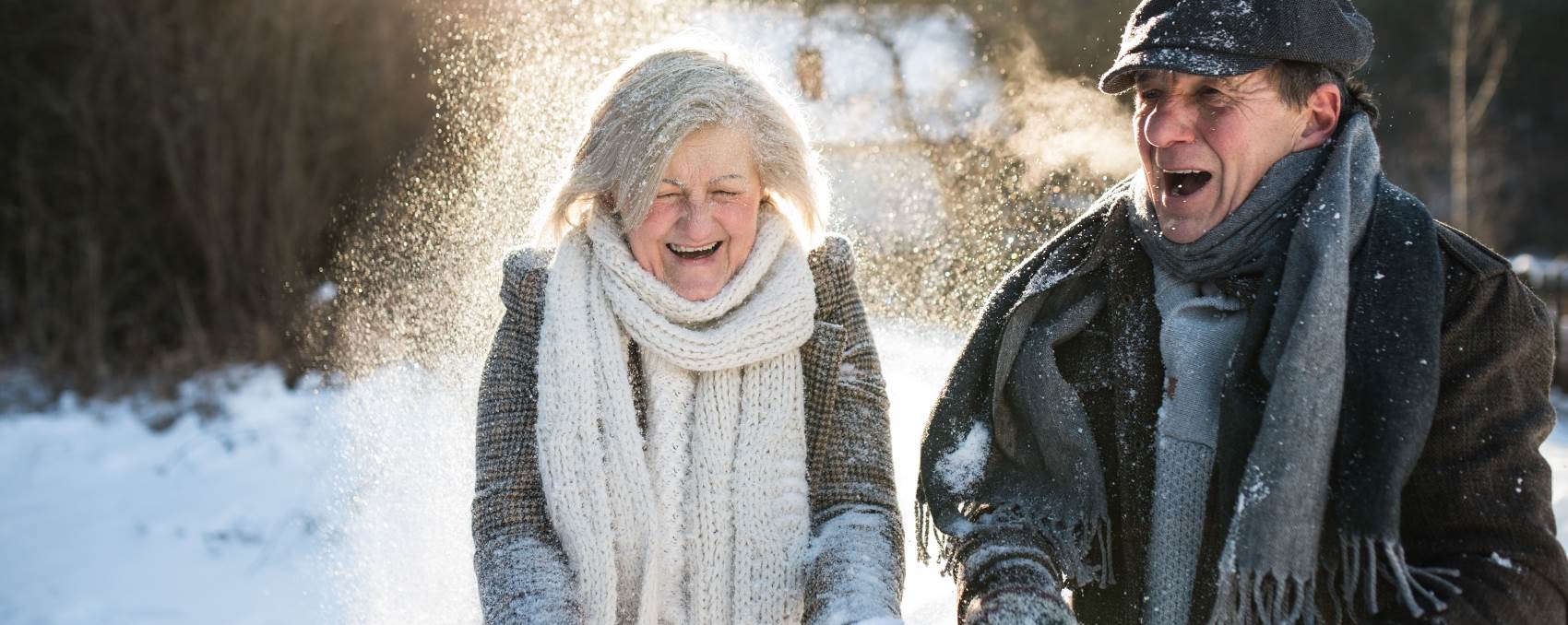 A senior man and woman enjoy a laugh in the winter.